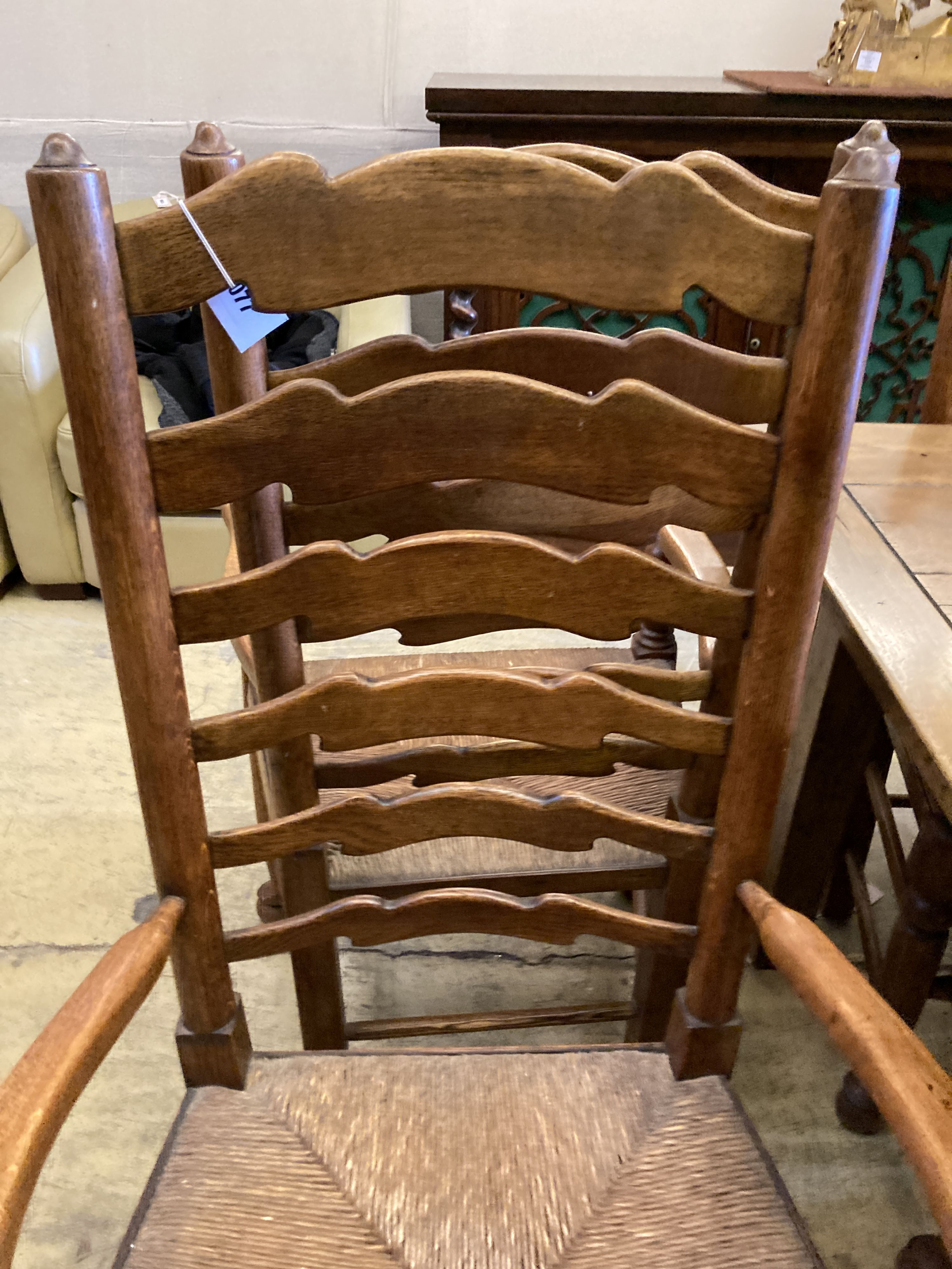 A set of six ladderback dining chairs with rush seats, two having arms